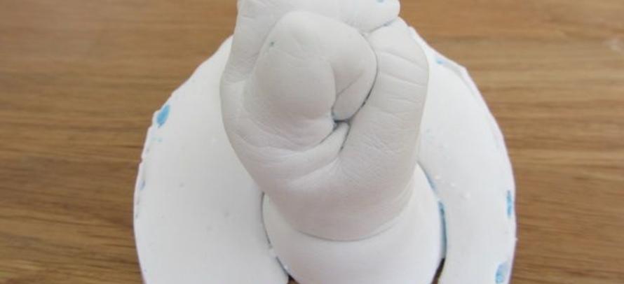 Een eerste babyhandje van porselein gips